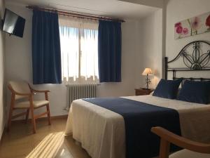 鲁伊德拉诺里亚酒店的卧室配有床、椅子和窗户。