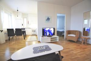 罗瓦涅米北极光公寓的客厅配有电视和桌子