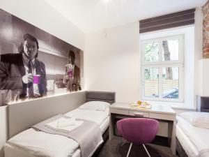 波兹南Cinema Hostel的一间设有两张床和一张紫色椅子的房间