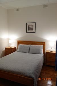 开普敦杰维斯Morella Farmstay的一间卧室配有一张带2个床头柜和2盏灯的床。