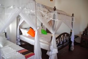 尼甘布缪拉荷兰边缘酒店的一间卧室配有带橙色和绿色枕头的天蓬床