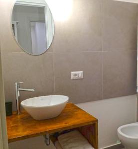 曼弗雷多尼亚B&B Acqua di Sale的浴室设有白色水槽和镜子
