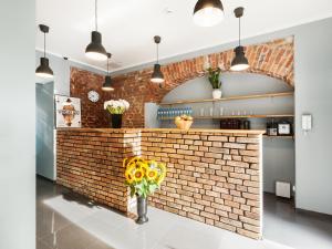 波兹南Cinema Hostel的厨房设有砖墙和向日葵花瓶