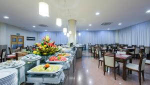 马瑙斯马瑙斯康福德酒店的用餐室配有桌椅和食物