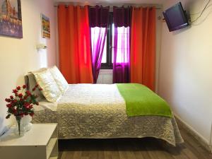 维勒瑞夫巴黎星酒店的一间卧室配有色彩缤纷的窗帘和一张床