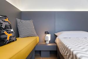 莫诺波利B&B Portorosso的一间卧室配有一张床,旁边设有一张黄色长椅