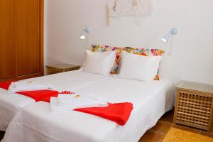 波塔莱格雷Eira Velha的一张白色的床,上面有红色的餐巾