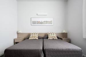 圣库加特德尔瓦勒斯罗伯托德诺比利君悦大学旅舍的一间卧室配有一张带两个枕头的床