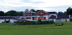 基拉尼Castlerosse Park Resort Holiday Homes的一座带绿色的高尔夫球场上的大型房子