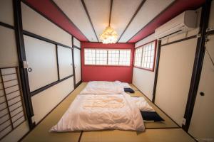 京都カモンイン 稲荷的红色墙壁和窗户的房间里一张床位