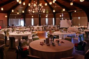 斯托纳姆杜拉克德拉格庄园酒店的一个带白色桌椅的大型宴会厅