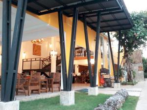 南邦รีสอร์ทที่ลำปาง (Resort At Lampang)的凉亭下设有木桌和椅子的餐厅