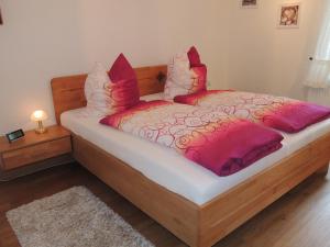 施内沃丁根Ferienhaus Snevern的一间卧室配有红色和白色枕头的床