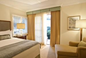 卡尔斯巴德阿维亚拉四季住宅俱乐部酒店的卧室配有床、椅子和窗户。