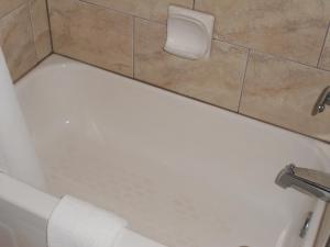 奥里利亚枫树汽车旅馆的浴室内设有带卷卫生纸的浴缸