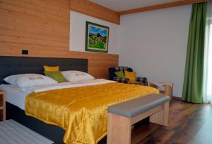 RogatecGuest House Gostišče Jutriša的一间卧室配有一张带黄色毯子的大床