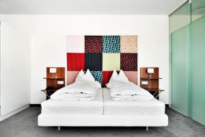 沃尔特湖畔韦尔登韦尔登赌场酒店的卧室配有白色床和色彩缤纷的墙壁