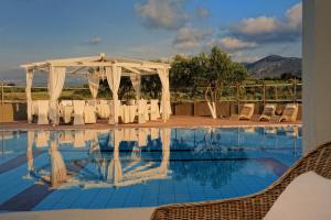 赫索尼索斯Paradise Island Villas的一个带桌椅和白色天篷的游泳池