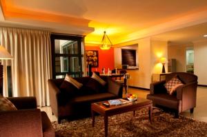 雅加达热带套房大酒店的客厅配有两张沙发和一张咖啡桌