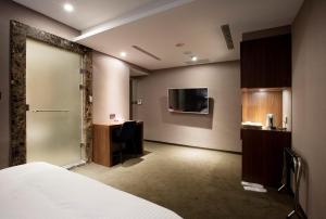 台北贵族商务饭店的酒店客房设有一张床、一张书桌和一台电视机。