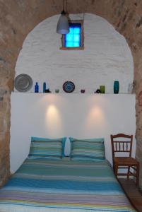 卡法斯Villa Spiti Elaionas的一间卧室配有一张带窗户和椅子的床