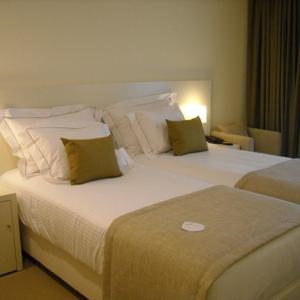 蓬德利马荫利马酒店及水疗中心的酒店客房配有一张带枕头的大型白色床。