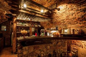 布拉索夫贝拉穆兹卡酒店的酒吧设有石墙和吧台