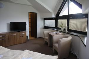 顺佩尔克Hotel Pod Radnicí的一间卧室配有一张床、一张桌子和一台电视。