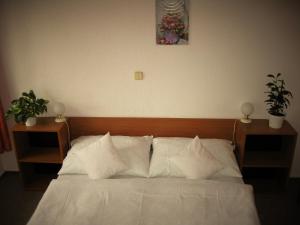 FulnekHotel Amos的卧室内的一张带白色床单和枕头的床