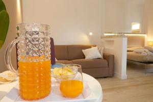蒙德罗B&B Mondello Design的桌上放着一罐橙汁和两杯酒