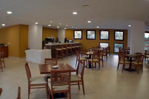 GraenaHotel Balneario de Graena的一间带桌椅的用餐室和一间酒吧