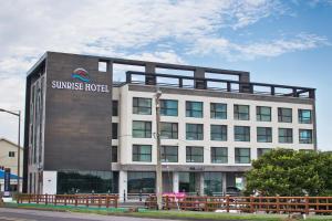 西归浦市Sunrise Hotel Seongsan的建筑的侧面有标志