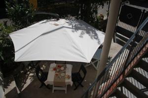 PilzoneCasa del Nespolo的一张桌子和椅子上的白色遮阳伞