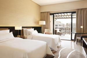 开罗The Westin Cairo Golf Resort & Spa, Katameya Dunes的带阳台的酒店客房内的两张床