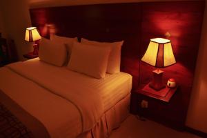 科伦坡独特大厦豪华精品套房酒店的卧室配有带两盏灯的白色床