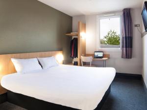 布西圣乔治B&B HOTEL Marne-la-Vallée Bussy-Saint-Georges的一间设有大床和窗户的酒店客房