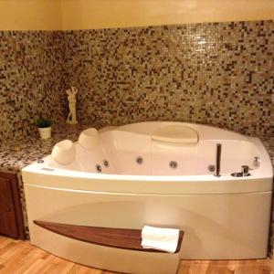 罗马圣彼得豪华公寓的浴室设有白色浴缸,浴室设有瓷砖墙