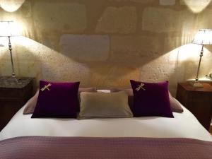 波尔多MAISON D'HÔTES "Bordeaux Wine Lodge"的一张带两个紫色枕头和两盏灯的床