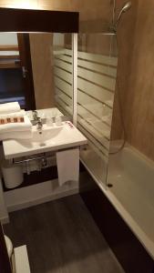 莱索尔莱斯艾克林斯酒店的浴室配有盥洗盆、镜子和浴缸
