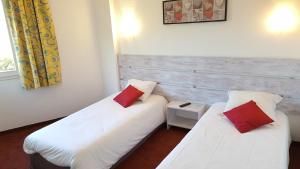 莱索尔莱斯艾克林斯酒店的配有白色和红色枕头的客房内的两张床