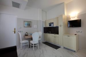 里米尼Hotel Residence Villa Del Mare的客房设有厨房和桌椅