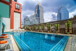 曼谷Bandara Silom Suites, Bangkok的一座位于城市的游泳池,有高大的建筑