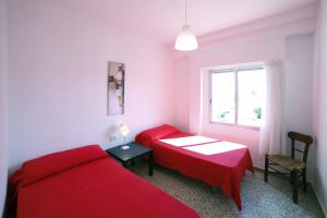 贝利雷瓜尔德Apartamento frente al mar的一间卧室设有两张红色的床和窗户