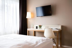 Steinenbronn克朗酒店的一间卧室配有一张床和一张桌子,墙上配有电视