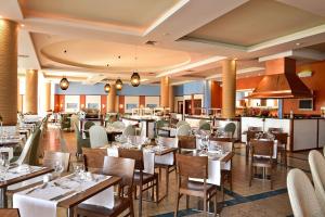 圣港Pestana Porto Santo Beach Resort & SPA的一间带桌椅的餐厅和一间酒吧