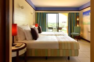 圣港Pestana Porto Santo Beach Resort & SPA的酒店客房设有床、桌子和窗户。