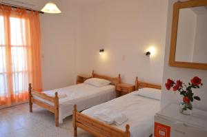 Agia Theodoti科乌科斯旅馆的一间卧室设有两张床和花瓶