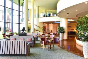 丰沙尔Pestana Grand Ocean Resort Hotel的大堂设有桌椅和窗户。