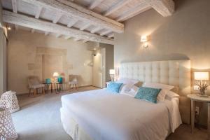 LaudunBoutique Hôtel La Villa MONTESQUIEU的卧室配有带蓝色枕头的大型白色床
