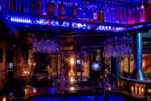 采尔马特后台精品SPA酒店的架子上装有蓝色灯和玻璃杯的酒吧